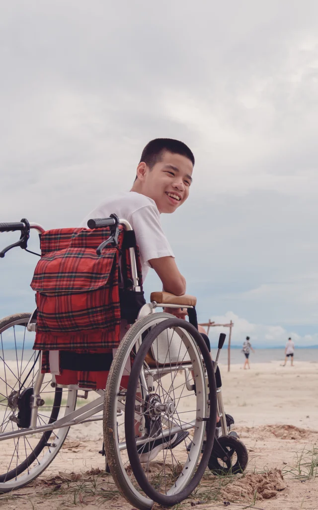 Young man with disability happy face, smiling on the beach,Outdoor vacation in summer,People leisure travel, mental health concept,Positive of lifestyle,International Day of Persons with Disabilities.