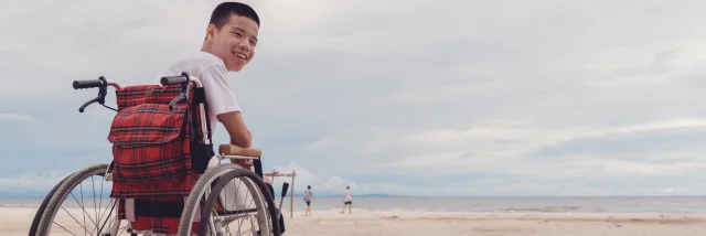 Young man with disability happy face, smiling on the beach,Outdoor vacation in summer,People leisure travel, mental health concept,Positive of lifestyle,International Day of Persons with Disabilities.